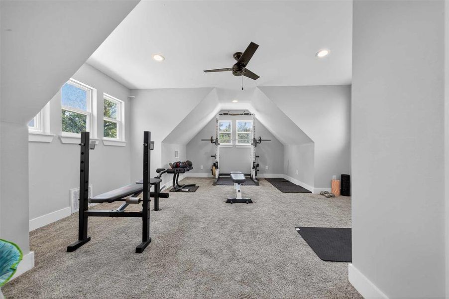 Exercise room with lofted ceiling, carpet floors, recessed lighting, and a ceiling fan Exercise room with lofted ceiling, carpet floors, recessed lighting, and a ceiling fan