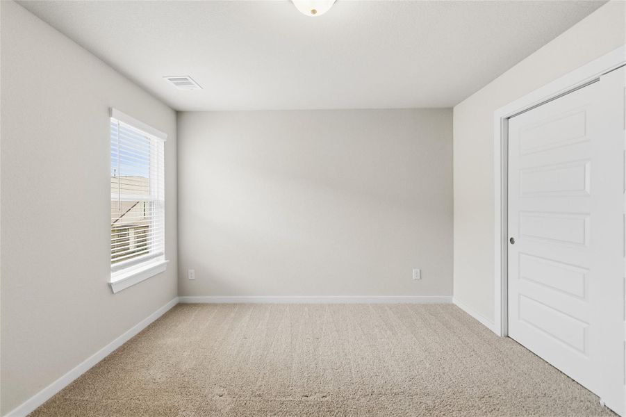 Your third secondary bedroom offers plush carpeting, a large window, and generous closet space—ideal for family, guests, or a home office.