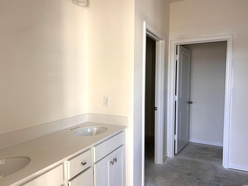 Bathroom featuring double vanity and concrete floors