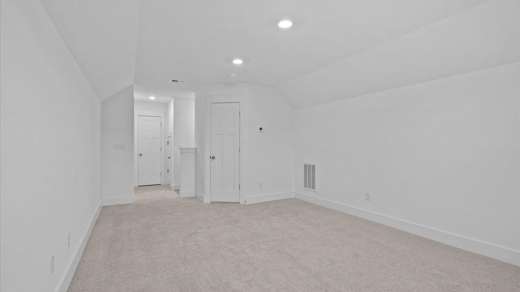Elegant bedroom retreat featuring soft carpet and oversized windows that create a bright, welcoming space