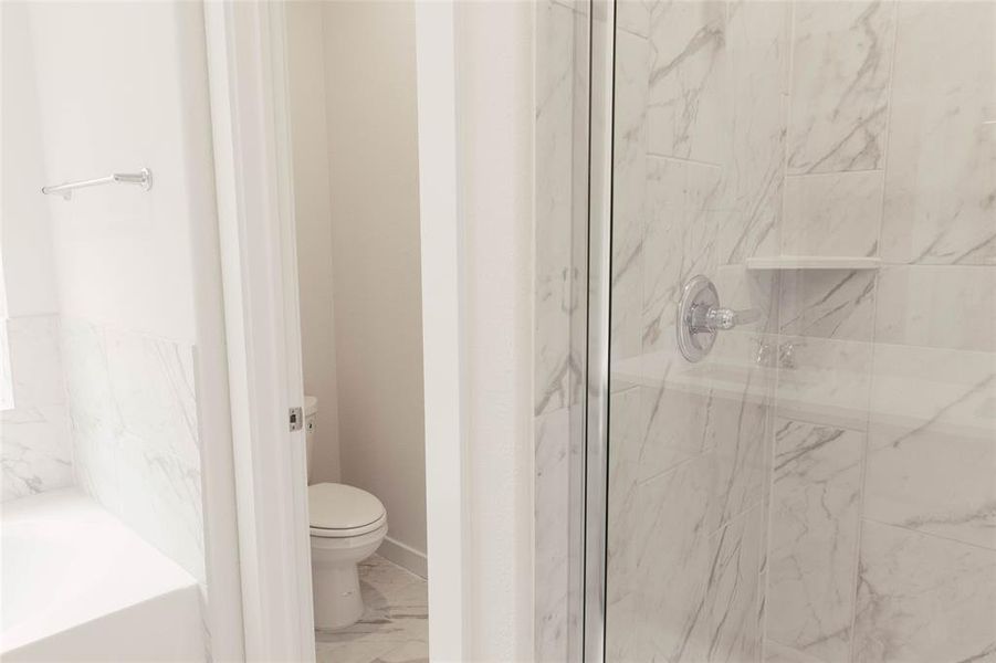 Bathroom featuring tile patterned floors, toilet, and separate shower and tub