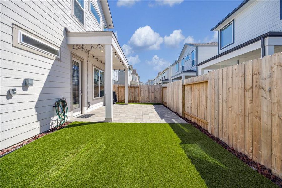 Upgraded backyard patio pavers with turf for low maintenance living.