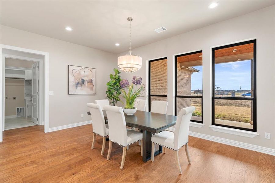 Dining area with a notable chandelier and light hardwood / wood-style flooring