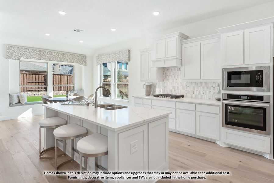 Kitchen with white cabinets, center island with seating, stainless steel appliances, and light hardwood floors Kitchen with white cabinets, center island with seating, stainless steel appliances, and light hardwood floors