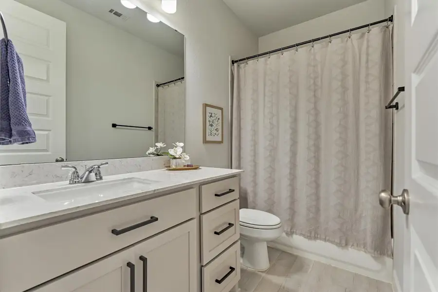 Secondary bath has upgraded matte black cabinet and plumbing hardware.