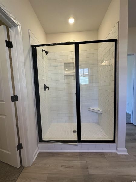Full bath featuring light wood-type flooring and a shower stall