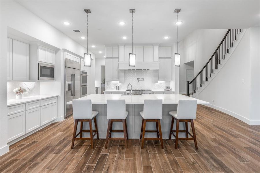 WOW!  This amazing kitchen is truly the heart of the home.  Floor to ceiling stacked cabinets, impressive quartzite island and exceptional lighting are just a few highlights of this sparkling space.