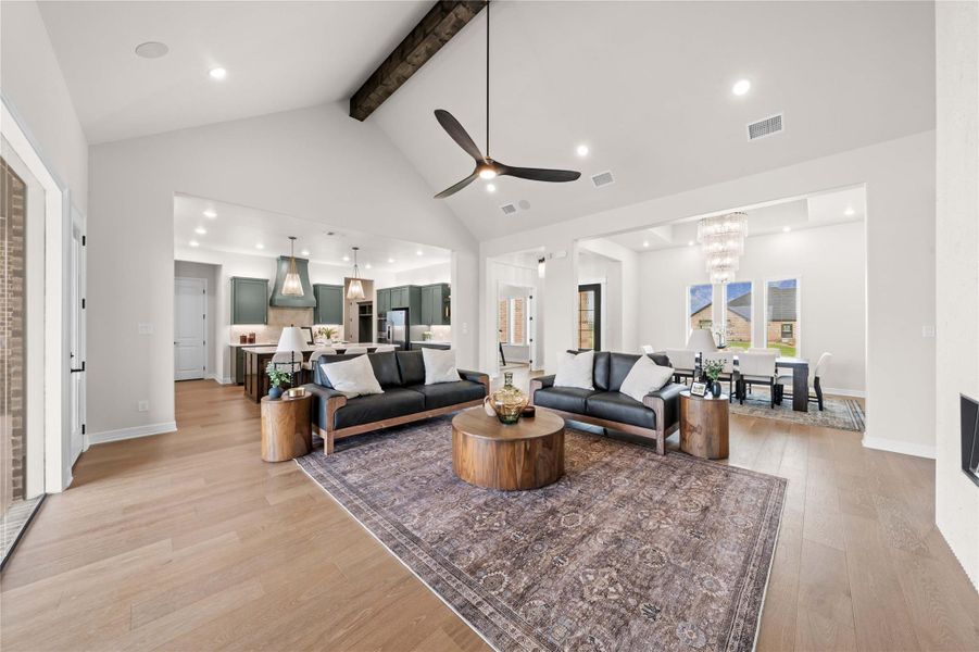 A spacious, naturally illuminated living area transitions smoothly into a modern kitchen and elegant dining space. A spacious, naturally illuminated living area transitions smoothly into a modern kitchen and elegant dining space.