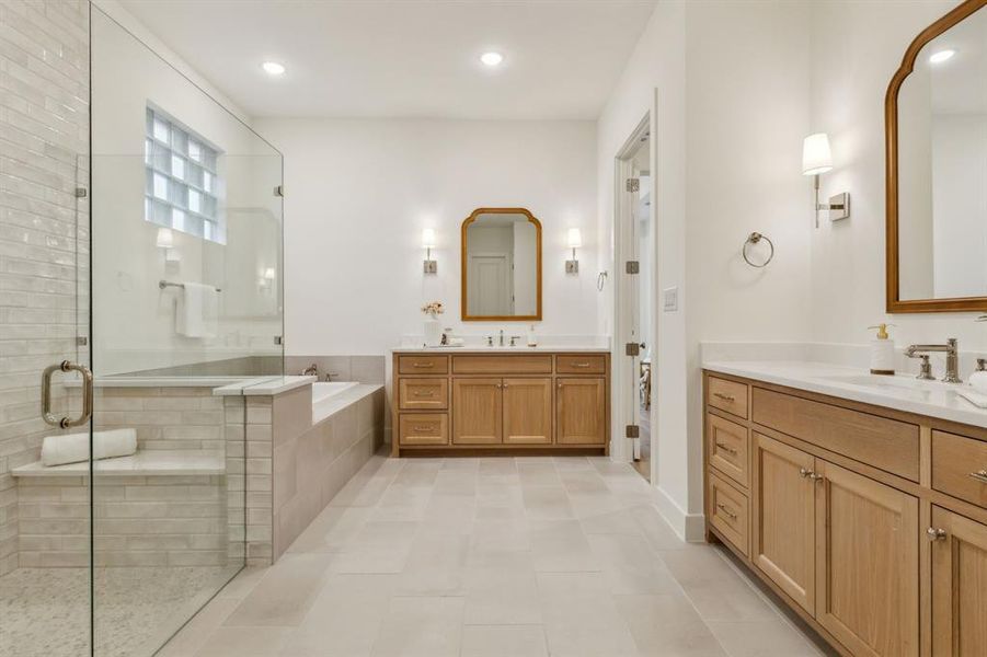 Bathroom featuring vanity, tile patterned floors, and shower with separate bathtub