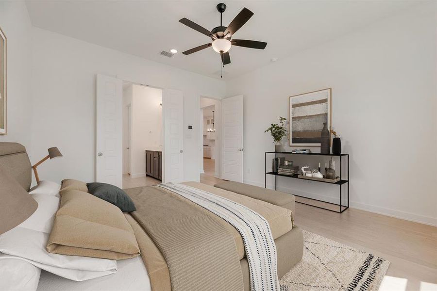 Bedroom featuring light wood finished floors, a ceiling fan, and connected bathroom Bedroom featuring light wood finished floors, a ceiling fan, and connected bathroom