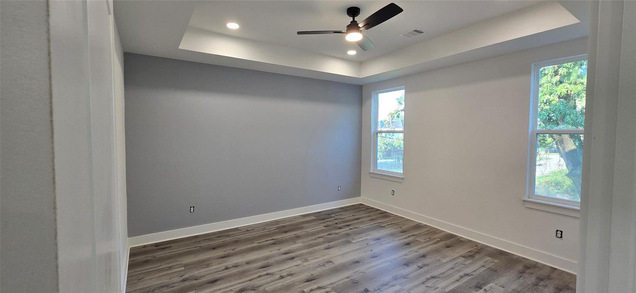 Primary bedroom with coffered ceiling and adjoining master bath suite.