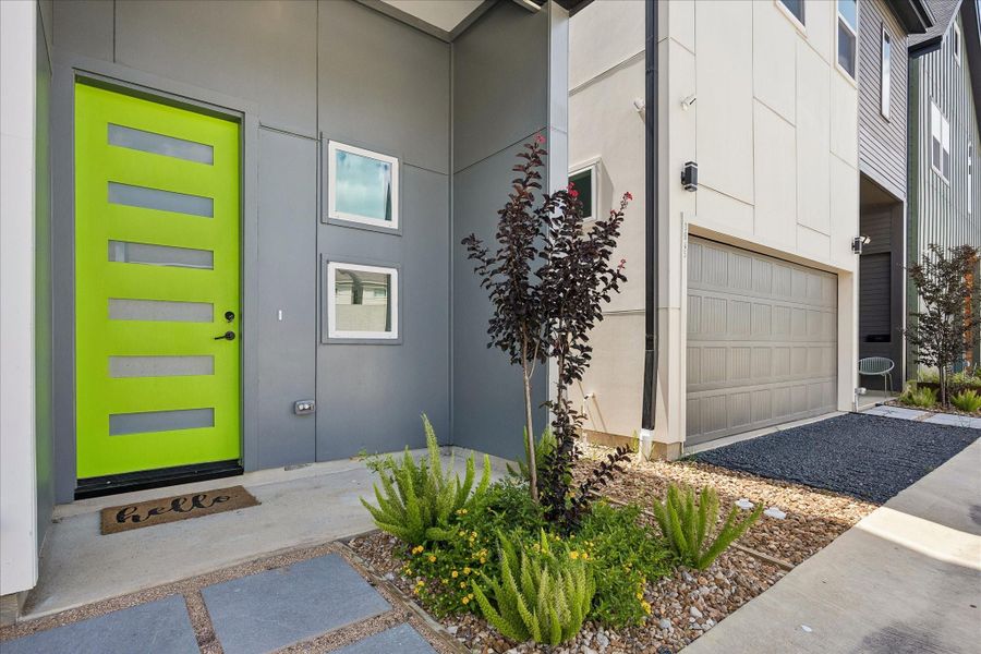 Inviting front entry featuring a bold designer door, contemporary landscaping, and clean architectural detailing. Inviting front entry featuring a bold designer door, contemporary landscaping, and clean architectural detailing.