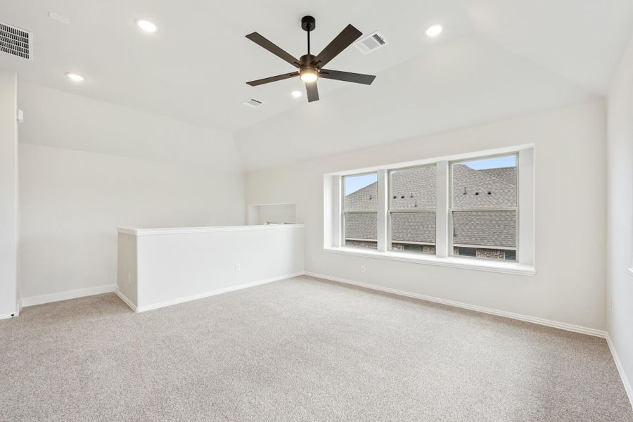 Empty room with carpet flooring, ceiling fan, recessed lighting, and large triple window with neighborhood view