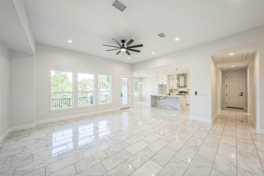 Unfurnished living room with recessed lighting, attic access, light marble finish flooring, and ceiling fan