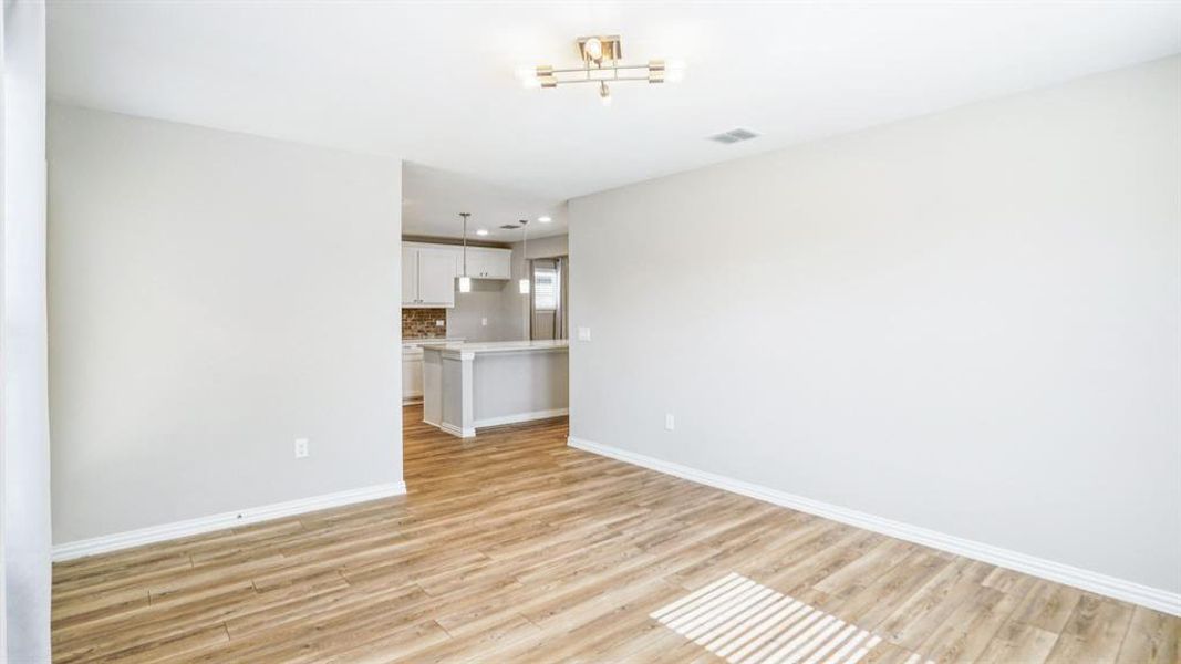 Unfurnished living room with baseboards and light wood-style floors Unfurnished living room with baseboards and light wood-style floors
