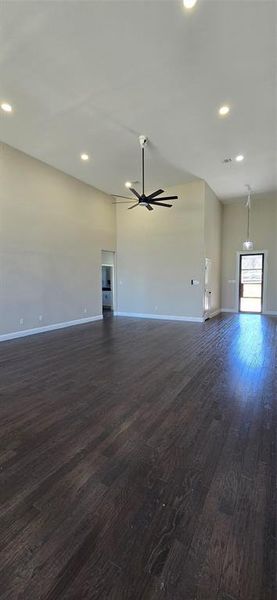 Unfurnished living room with dark wood-style floors, ceiling fan, and recessed lighting Unfurnished living room with dark wood-style floors, ceiling fan, and recessed lighting