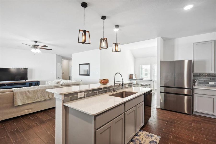 Kitchen featuring stainless steel fridge, sink, and gray cabinetry