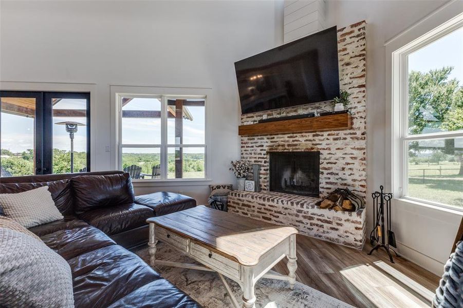 Living room with a wealth of natural light, hardwood / wood-style flooring, and a fireplace Living room with a wealth of natural light, hardwood / wood-style flooring, and a fireplace