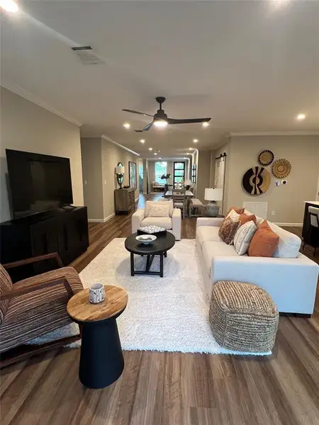 Living area with wood finished floors, ornamental molding, recessed lighting, and a ceiling fan