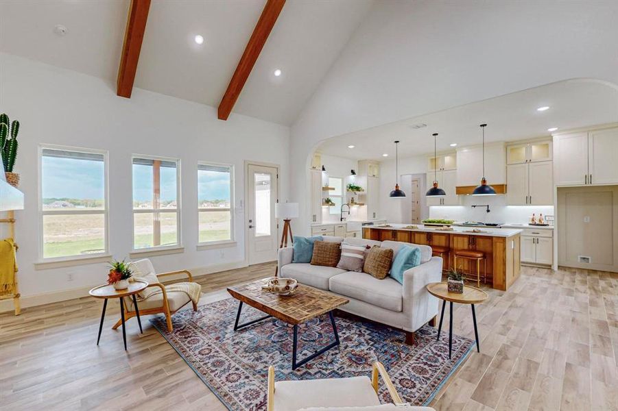 Living room with high vaulted ceiling, beamed ceiling, and light wood-type flooring