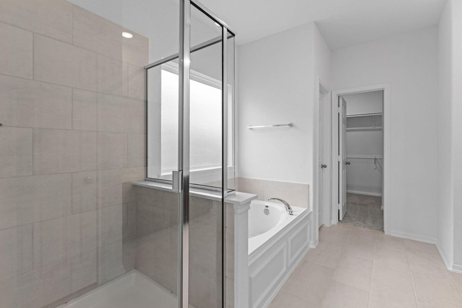 This additional view of your primary bathroom features tile flooring, fresh paint, walk-in shower, a separate garden tub, and a large walk-in closet. This additional view of your primary bathroom features tile flooring, fresh paint, walk-in shower, a separate garden tub, and a large walk-in closet.
