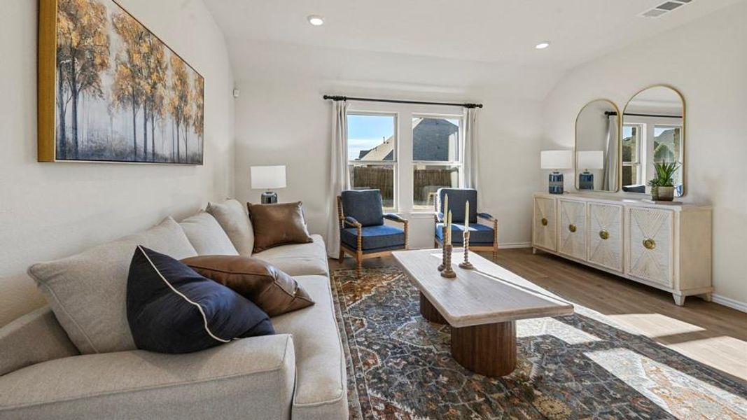 Living room featuring vaulted ceiling, recessed lighting, and wood finished floors