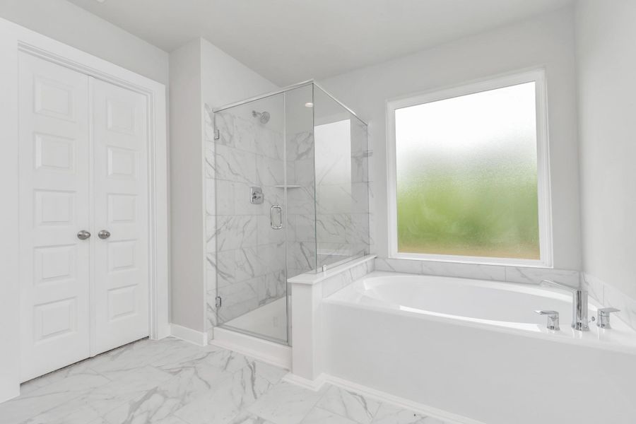 This additional view of the primary bath features a walk-in shower with the tile surround and separate garden tub perfect for soaking after a long day. Sample photo of completed home with similar floor plan. Actual colors and selections may vary. This additional view of the primary bath features a walk-in shower with the tile surround and separate garden tub perfect for soaking after a long day. Sample photo of completed home with similar floor plan. Actual colors and selections may vary.