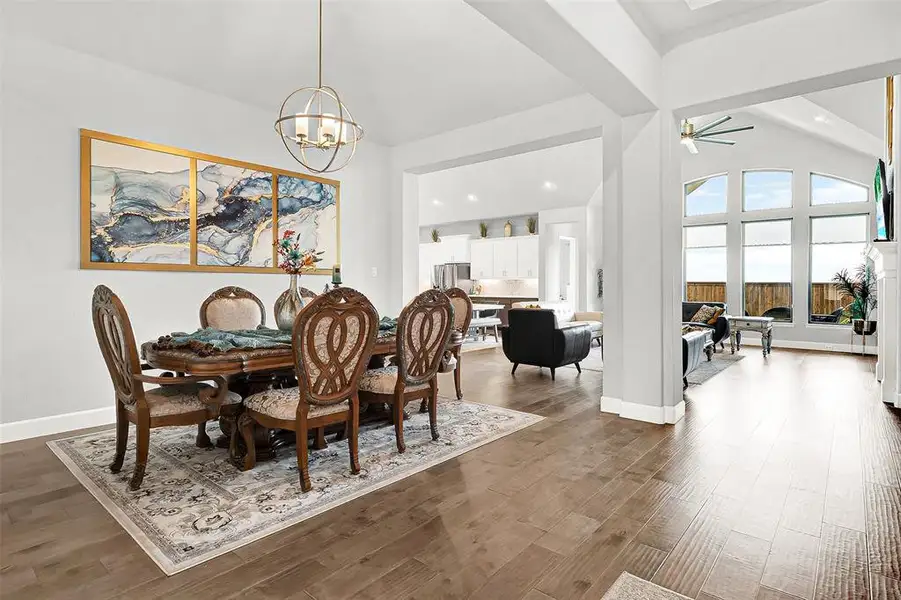 Dining space featuring a ceiling fan, wood finished floors, high vaulted ceiling, recessed lighting, and a chandelier Dining space featuring a ceiling fan, wood finished floors, high vaulted ceiling, recessed lighting, and a chandelier