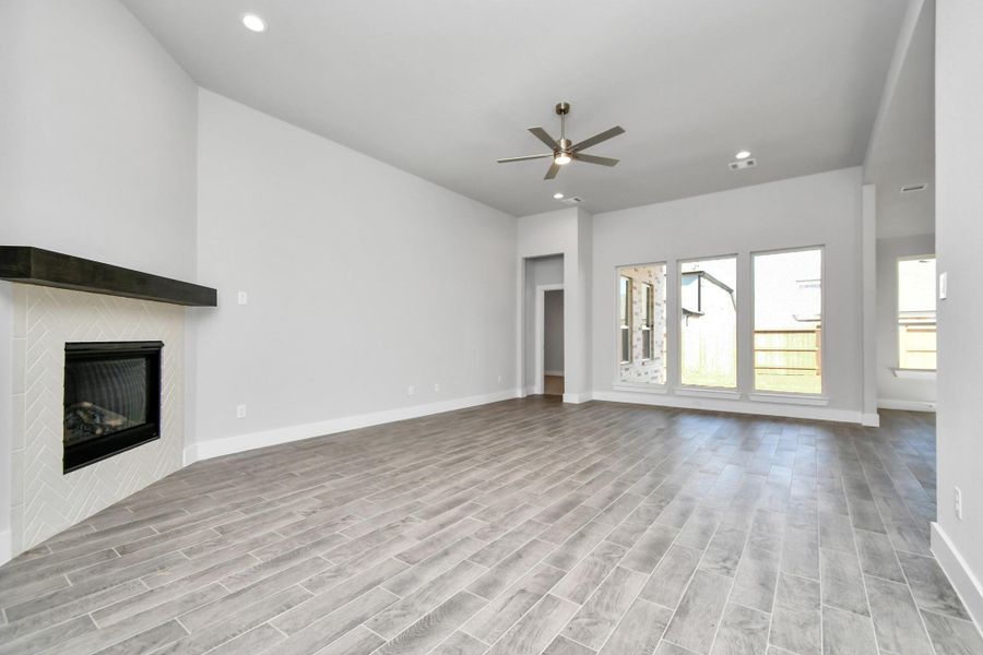 Bring your loved ones and guests together in the inviting living room! Boasting lofty high ceilings, recessed lighting, cozy gas log fireplace, a stylish ceiling fan, custom paint, stunning flooring, and expansive windows that flood the space with ample natural light all day long. Sample photo of completed home with similar plan. As built color and selections will vary. Bring your loved ones and guests together in the inviting living room! Boasting lofty high ceilings, recessed lighting, cozy gas log fireplace, a stylish ceiling fan, custom paint, stunning flooring, and expansive windows that flood the space with ample natural light all day long. Sample photo of completed home with similar plan. As built color and selections will vary.