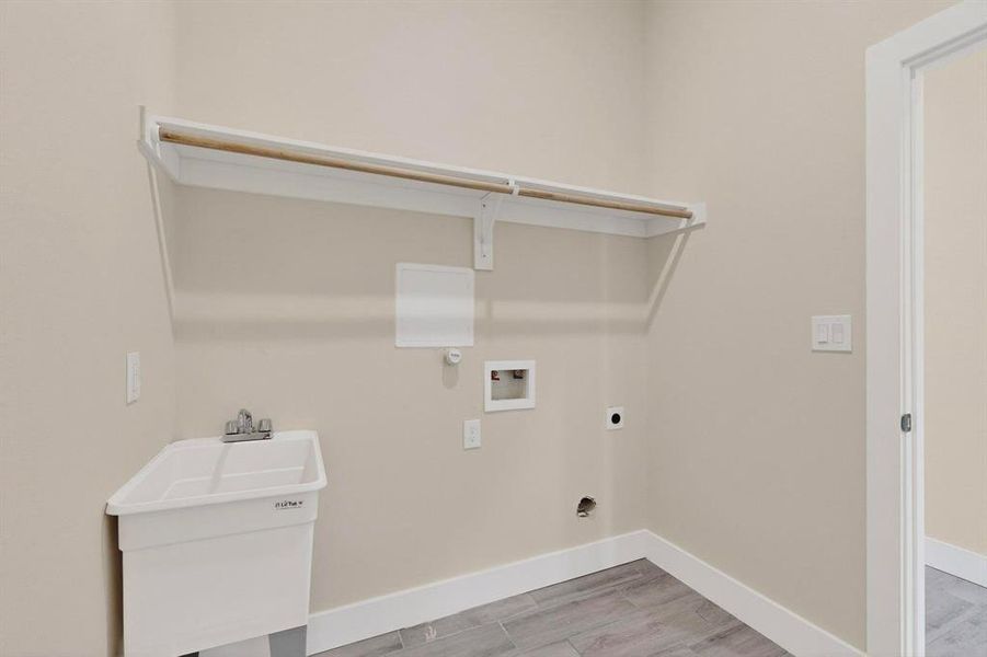 Laundry room with washer and dryer connections as well as a dedicated sink for added convenience. Laundry room with washer and dryer connections as well as a dedicated sink for added convenience.