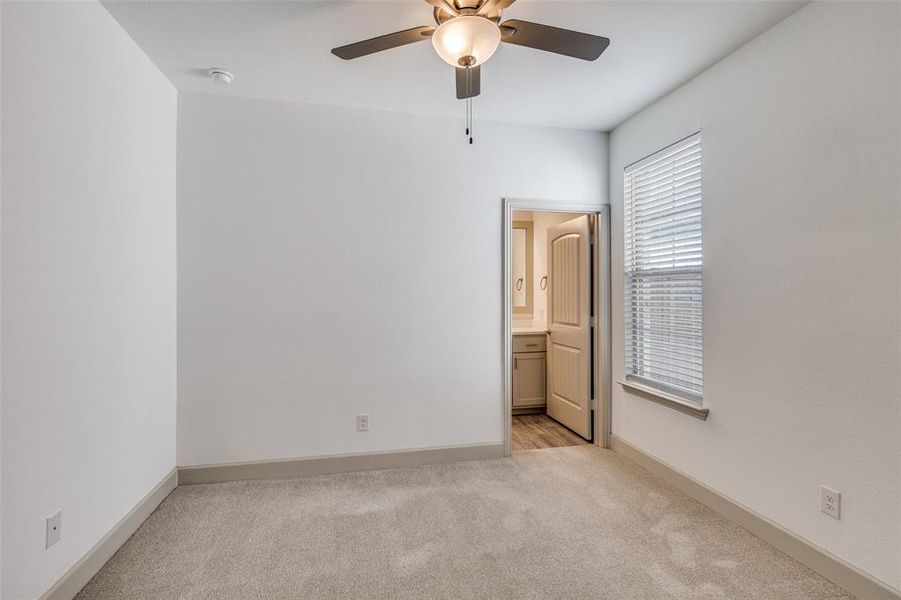 Unfurnished bedroom with light carpet, ensuite bathroom, and ceiling fan Unfurnished bedroom with light carpet, ensuite bathroom, and ceiling fan