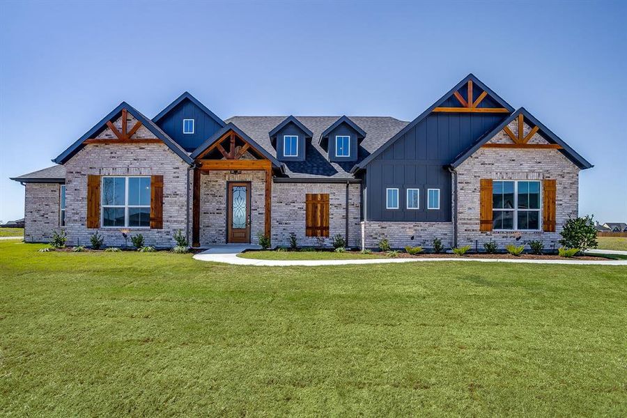 View of front of property with board and batten siding, a front lawn, and brick siding View of front of property with board and batten siding, a front lawn, and brick siding