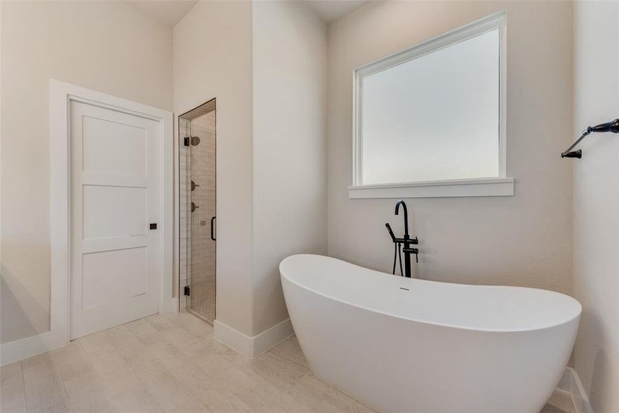 Bathroom featuring separate shower and tub and wood-type flooring