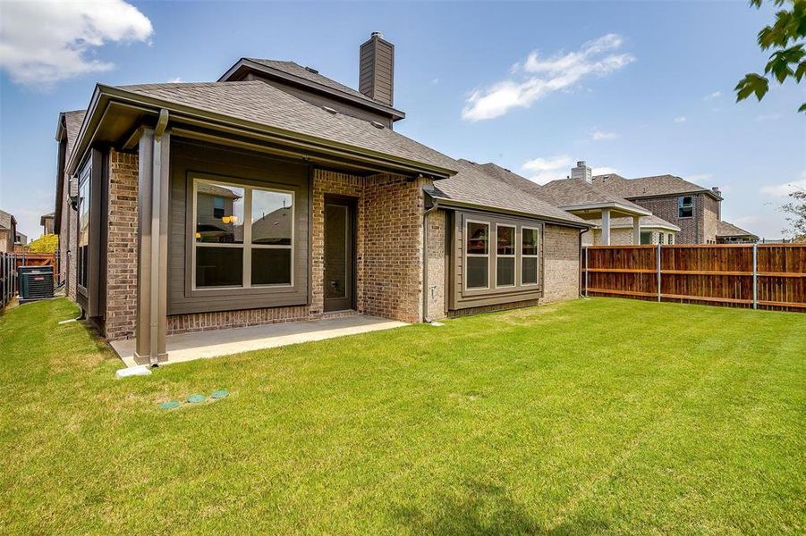 Back of house featuring a yard and central AC