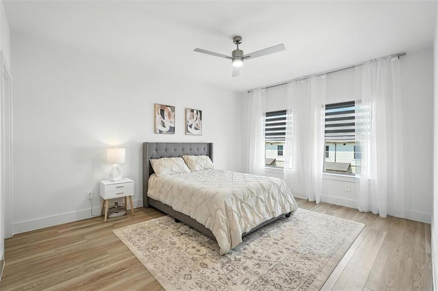 Bedroom with ceiling fan and light wood-style floors