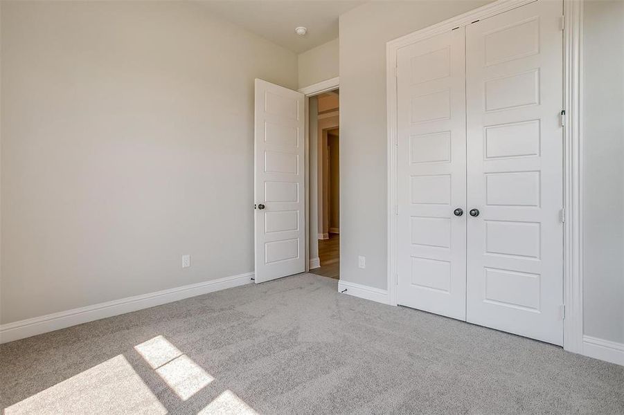 Unfurnished bedroom featuring a closet and light colored carpet