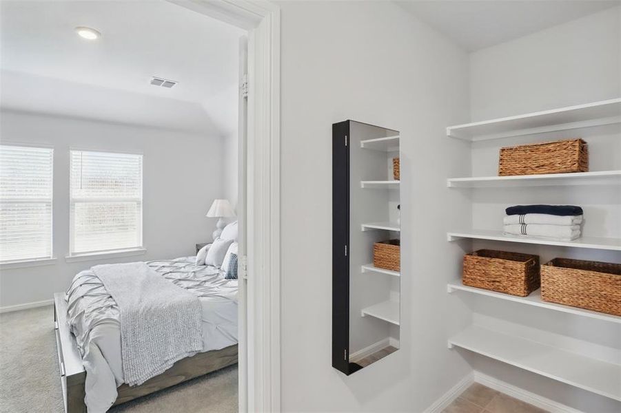 Carpeted bedroom featuring baseboards and visible vents