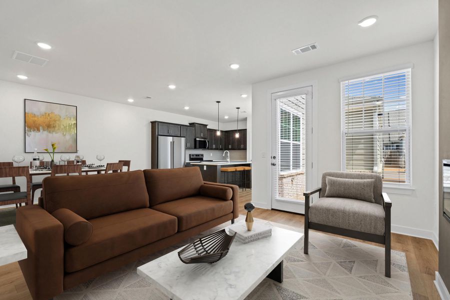 Open-concept living area featuring wood-finish flooring, recessed lighting, and a white color palette