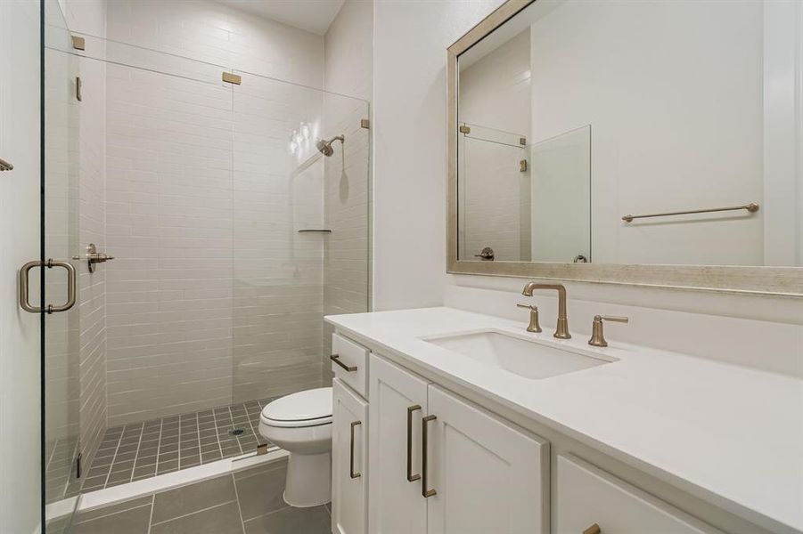 Full bath featuring vanity, a shower stall, and dark tile patterned floors Full bath featuring vanity, a shower stall, and dark tile patterned floors