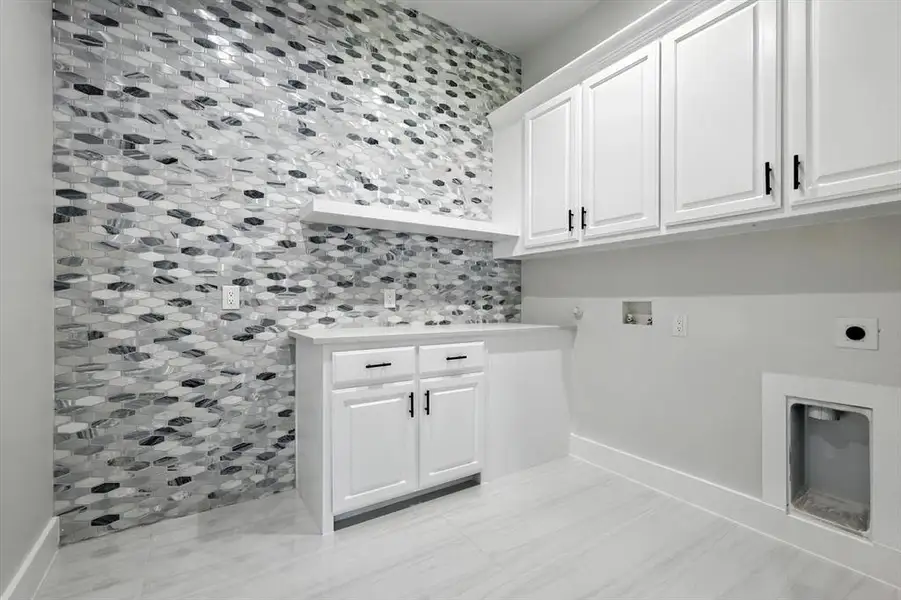 Laundry area featuring hookup for an electric dryer, cabinet space, washer hookup, and gas dryer hookup Laundry area featuring hookup for an electric dryer, cabinet space, washer hookup, and gas dryer hookup