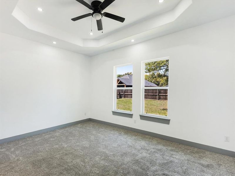 Spare room with a raised ceiling, carpet, a ceiling fan, and recessed lighting Spare room with a raised ceiling, carpet, a ceiling fan, and recessed lighting