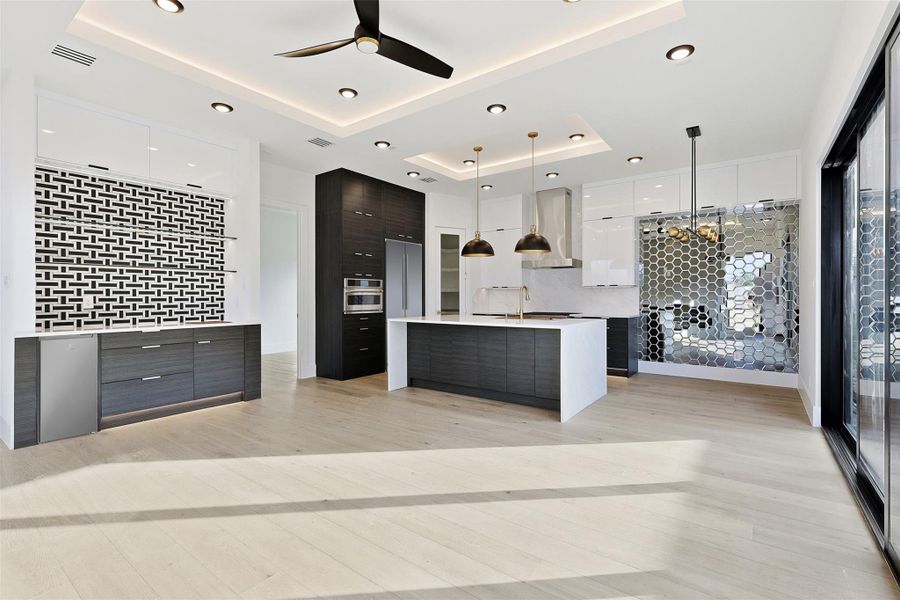 Same floorplan - different finishes. This modern kitchen integrates high-gloss white upper cabinets with dark wood-grain lowers and professional-grade stainless steel appliances.