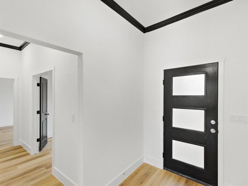 Foyer with ornamental molding and light wood finished floors Foyer with ornamental molding and light wood finished floors