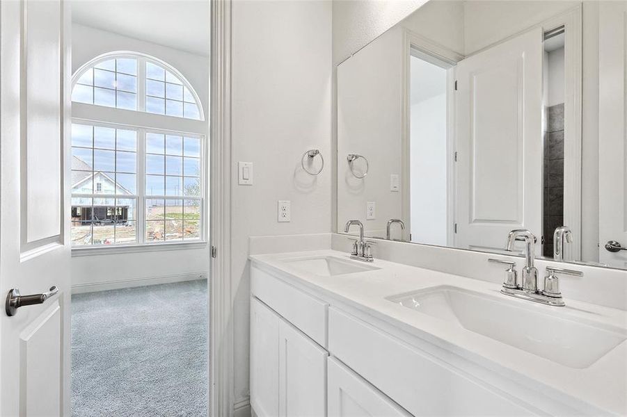 Full bath featuring double vanity and light colored carpet