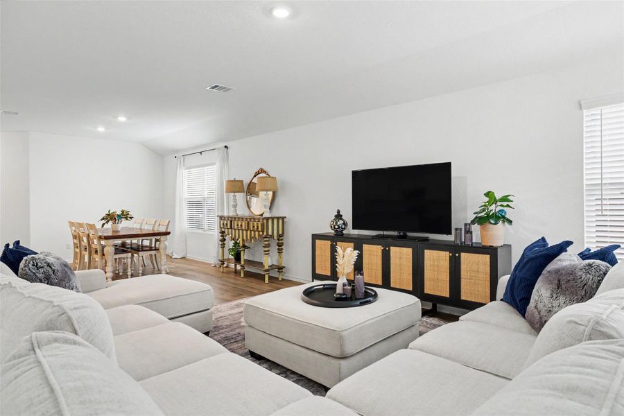 Spacious living area featuring wood-finish flooring, recessed lighting, and white window blinds