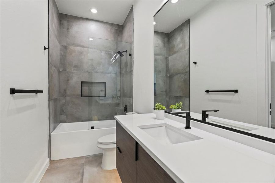 Full bathroom featuring vanity, toilet, and tiled shower / bath combo