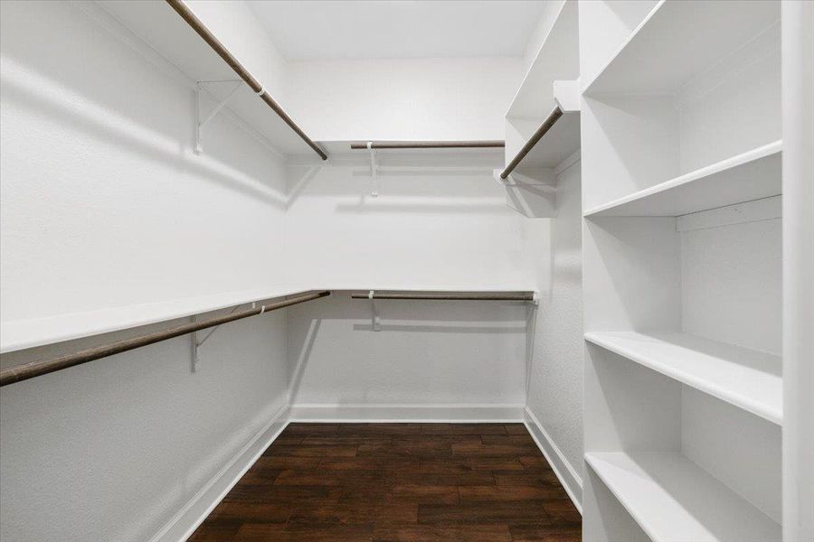 Walk in closet featuring dark wood-type flooring Walk in closet featuring dark wood-type flooring