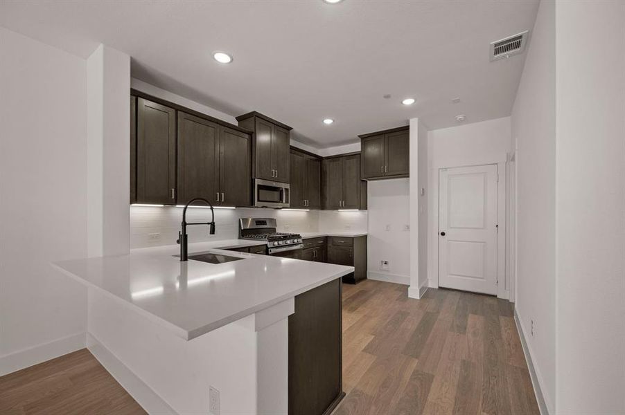 The kitchen peninsula offers a great place for a quick bite or homework station.