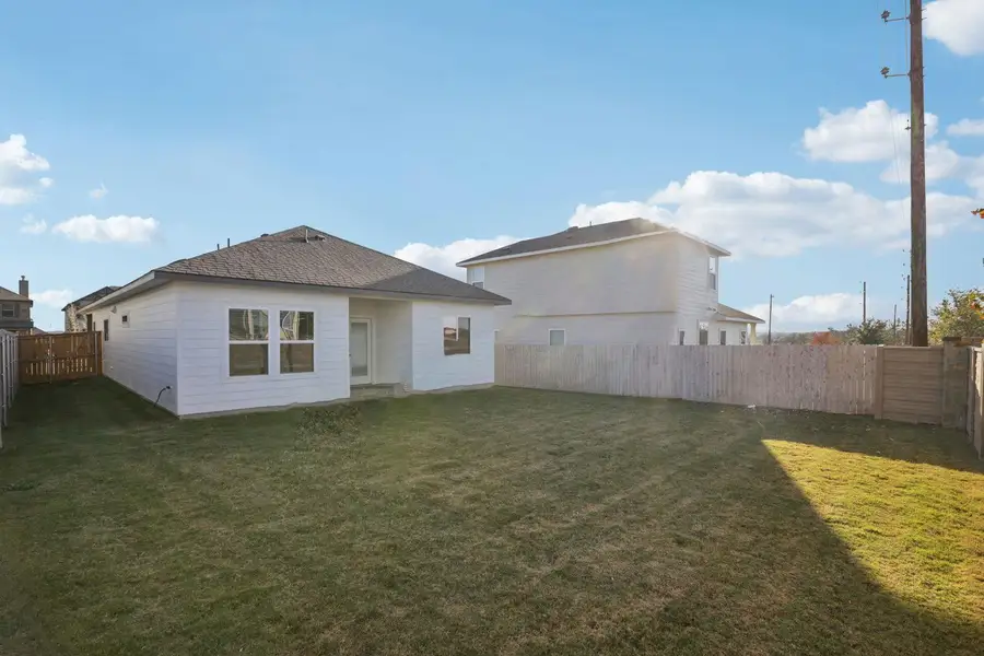 Rear view of property with a fenced backyard