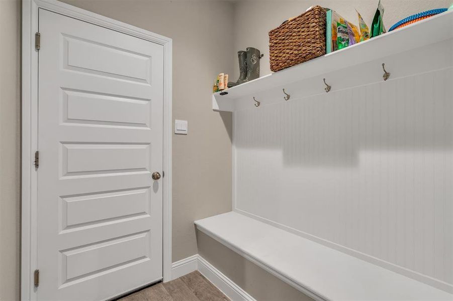 Mudroom with light wood-type flooring and baseboards